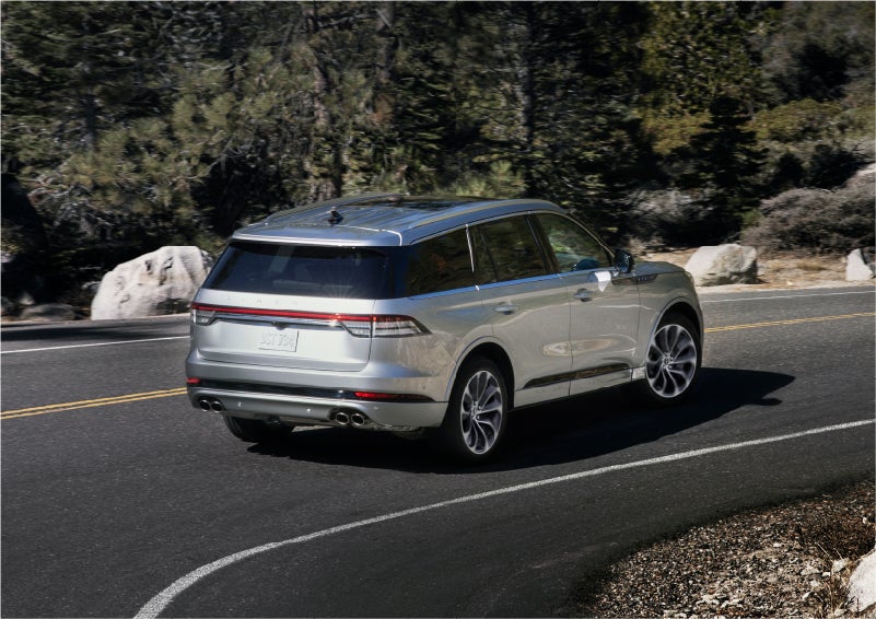 A 2023 Lincoln Aviator® Grand Touring model is shown being driven on a tight turn of a mountain road | Zeigler Lincoln of Kalamazoo in Kalamazoo MI