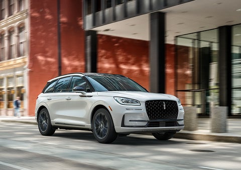 The 2024 Lincoln Corsair® SUV with the Jet Appearance Package and a Pristine White exterior is parked on a city street. | Zeigler Lincoln of Kalamazoo in Kalamazoo MI
