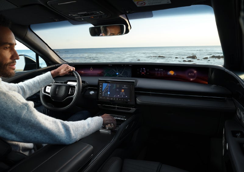 A driver of a parked 2024 Lincoln Nautilus® SUV takes a relaxing moment at a seaside overlook while inside his Nautilus. | Zeigler Lincoln of Kalamazoo in Kalamazoo MI