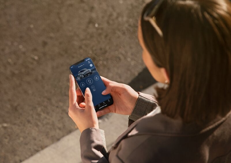 A person is shown interacting with a smartphone to connect to a Lincoln vehicle via the Lincoln Way® App. | Zeigler Lincoln of Kalamazoo in Kalamazoo MI