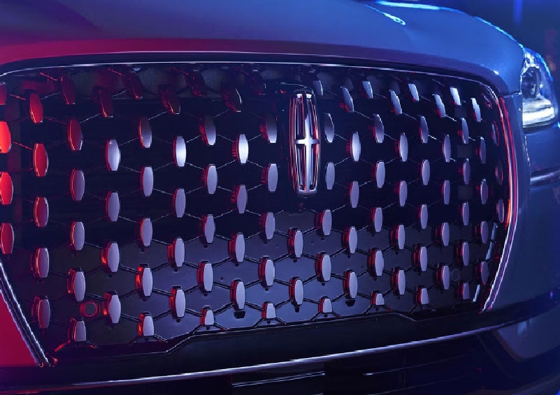 The grille of a 2025 Lincoln Corsair® SUV reflects neon light at night. | Zeigler Lincoln of Kalamazoo in Kalamazoo MI