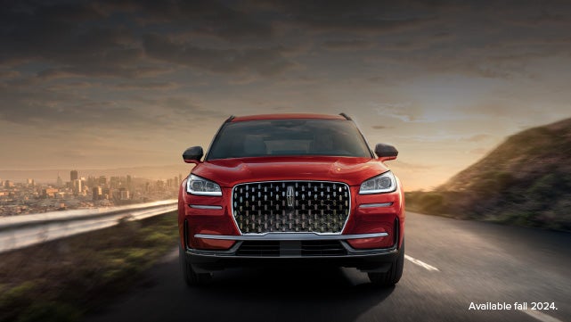 A 2025 red Lincoln Corsair® SUV is being driven down a road at sunset. | Zeigler Lincoln of Kalamazoo in Kalamazoo MI