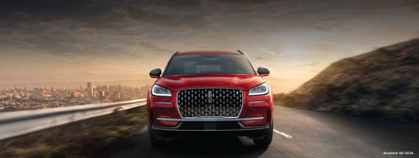 A 2025 red Lincoln Corsair® SUV is being driven down a road at sunset. | Zeigler Lincoln of Kalamazoo in Kalamazoo MI