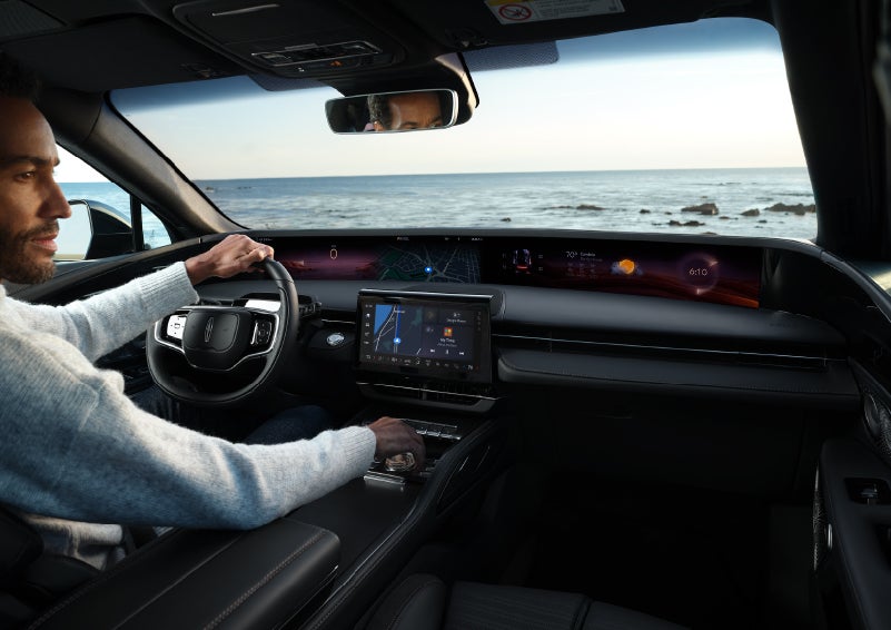 A driver of a parked 2025 Lincoln Nautilus® SUV takes a relaxing moment at a seaside overlook while inside his Nautilus. | Zeigler Lincoln of Kalamazoo in Kalamazoo MI