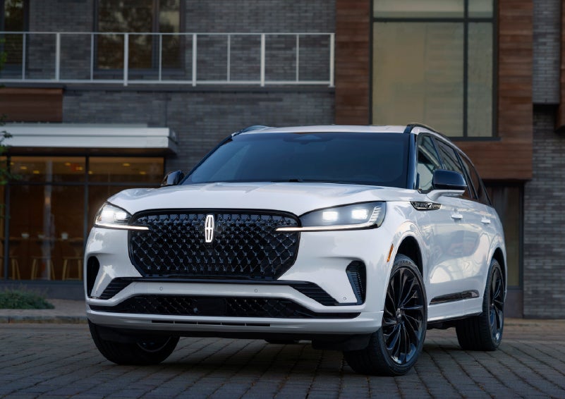 A 2026 Lincoln Aviator® Reserve model is shown with the available Jet Appearance Package parked near a restaurant. | Zeigler Lincoln of Kalamazoo in Kalamazoo MI