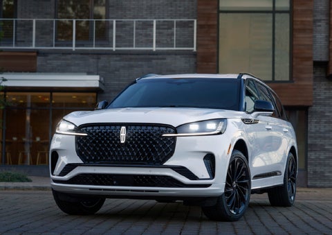 A 2026 Lincoln Aviator® Reserve model is shown with the available Jet Appearance Package parked near a restaurant. | Zeigler Lincoln of Kalamazoo in Kalamazoo MI