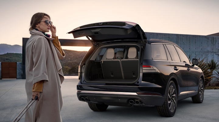A woman approaches a 2026 Lincoln Aviator® SUV with its rear liftgate open. | Zeigler Lincoln of Kalamazoo in Kalamazoo MI