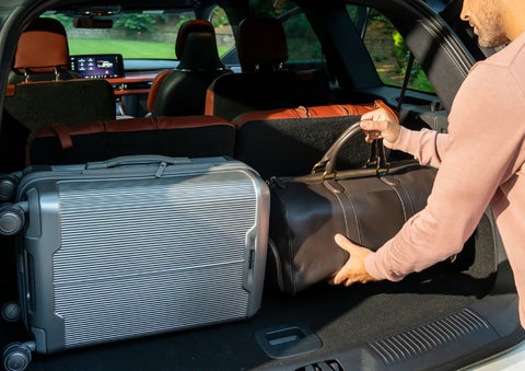 A man loads luggage into the rear of a 2026 Lincoln Aviator® SUV through the opened rear liftgate. | Zeigler Lincoln of Kalamazoo in Kalamazoo MI
