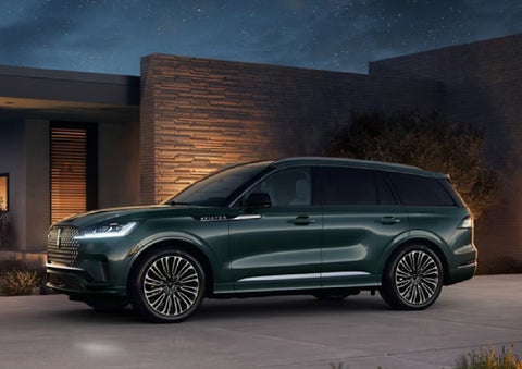 A green 2027 Lincoln Aviator® SUV is parked outside a contemporary home. | Zeigler Lincoln of Kalamazoo in Kalamazoo MI