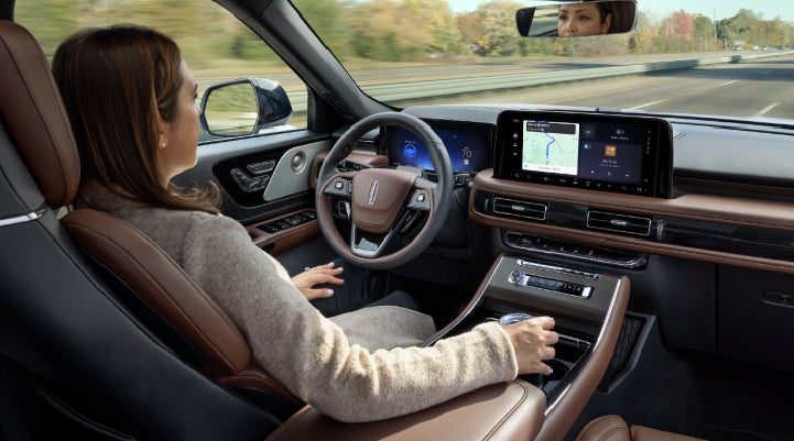 A 2027 Lincoln Aviator® SUV is being driven hands-free on a highway lined with trees. | Zeigler Lincoln of Kalamazoo in Kalamazoo MI