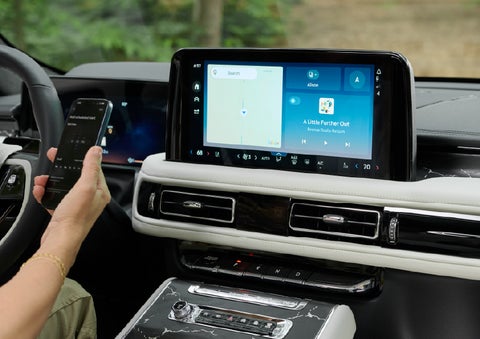 A person pairs thier phone with the center touchscreen of a 2027 Lincoln Aviator® Black Label™ SUV | Zeigler Lincoln of Kalamazoo in Kalamazoo MI